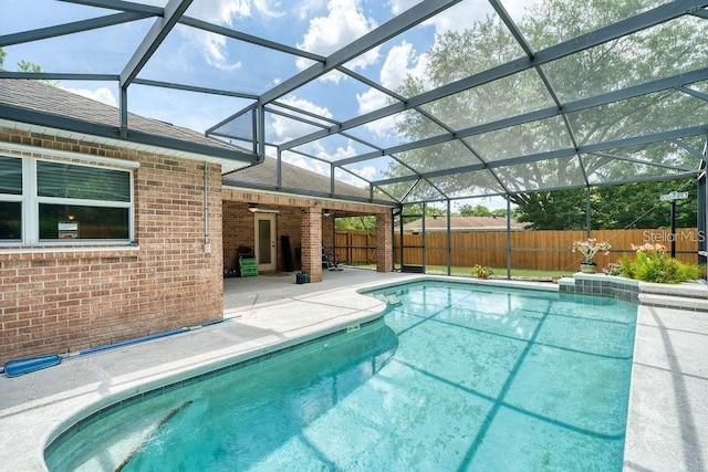 view of swimming pool with a patio area and glass enclosure