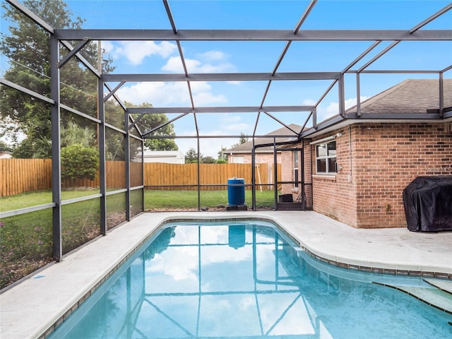 view of pool with a lanai, area for grilling, a yard, and a patio area