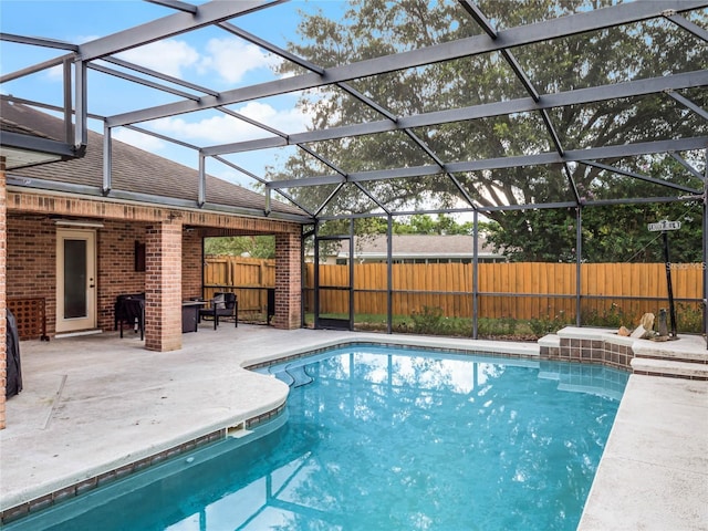 view of swimming pool with a patio area and glass enclosure