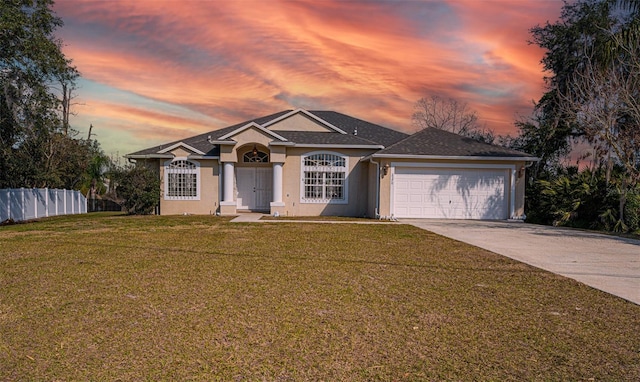 ranch-style home featuring a yard and a garage