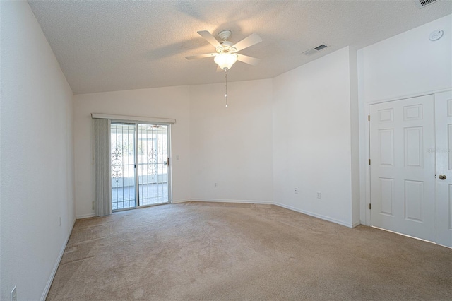 carpeted spare room with ceiling fan, lofted ceiling, and a textured ceiling