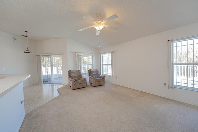 unfurnished room with ceiling fan, lofted ceiling, light carpet, and a textured ceiling