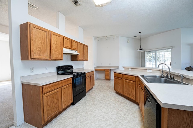 kitchen with sink, decorative light fixtures, a textured ceiling, an island with sink, and black appliances