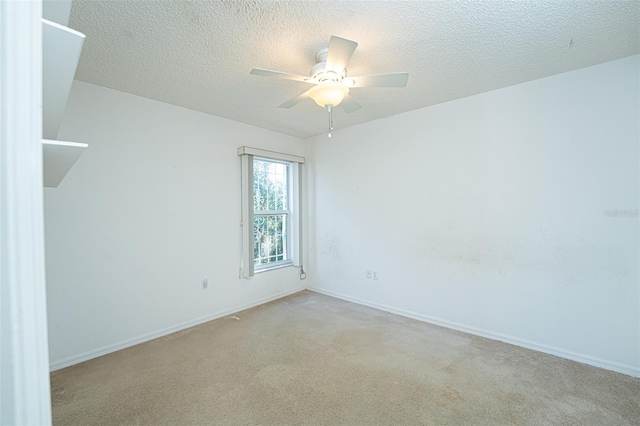 empty room with light carpet, a textured ceiling, and ceiling fan