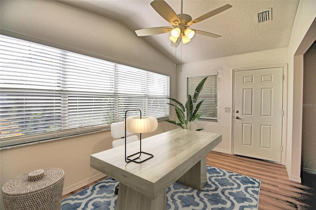 home office featuring ceiling fan, lofted ceiling, a textured ceiling, and light hardwood / wood-style floors