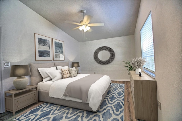 bedroom with hardwood / wood-style flooring, vaulted ceiling, a textured ceiling, and ceiling fan