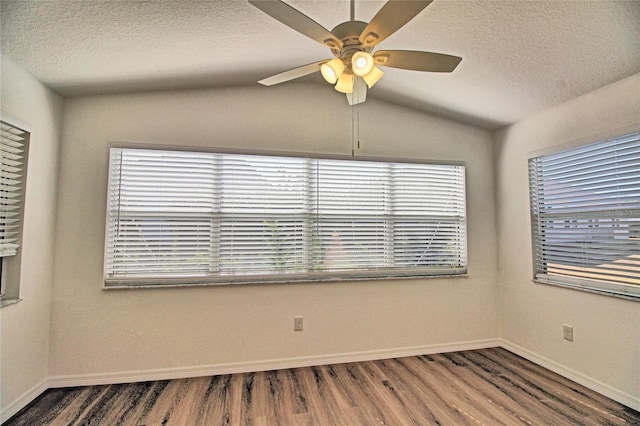 spare room featuring lofted ceiling, ceiling fan, wood-type flooring, and a textured ceiling