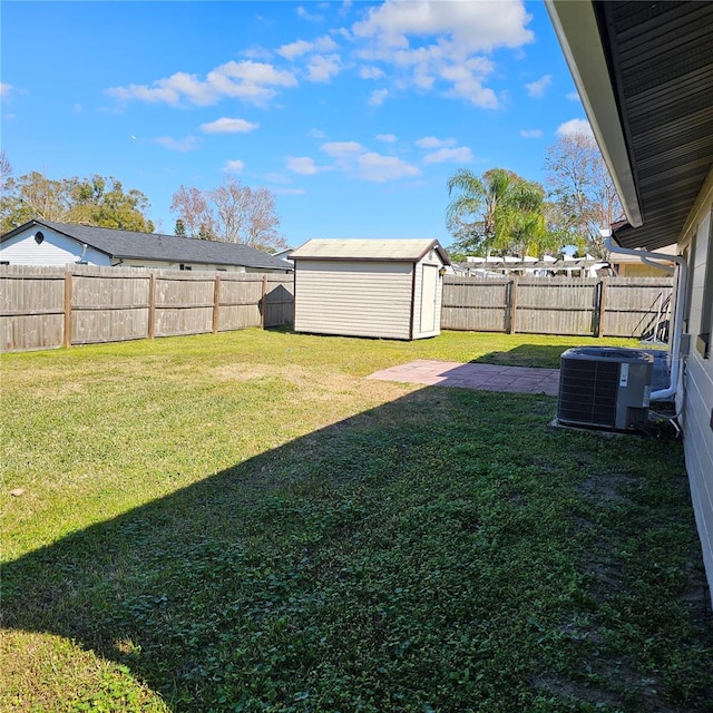 view of yard with central AC unit and a storage shed