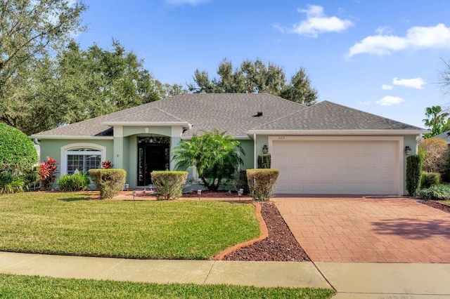 single story home featuring a garage and a front lawn