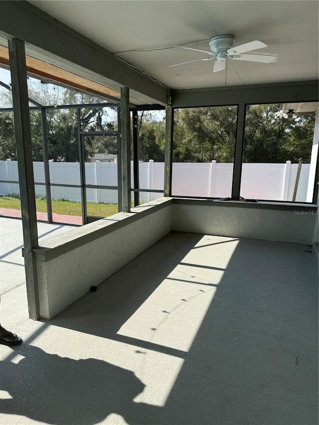 unfurnished sunroom featuring plenty of natural light and ceiling fan