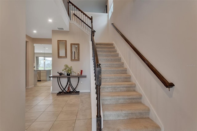 stairs with a towering ceiling and tile patterned flooring