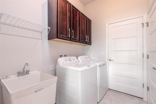 laundry area featuring cabinets, separate washer and dryer, and sink