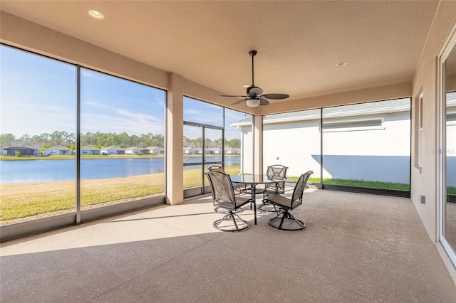 sunroom with a water view, a wealth of natural light, and ceiling fan