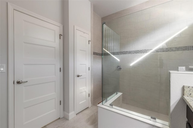 bathroom with a tile shower and vanity