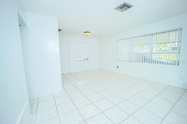 unfurnished room featuring a textured ceiling