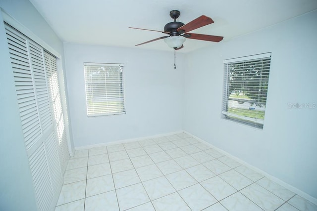 spare room featuring ceiling fan and a healthy amount of sunlight