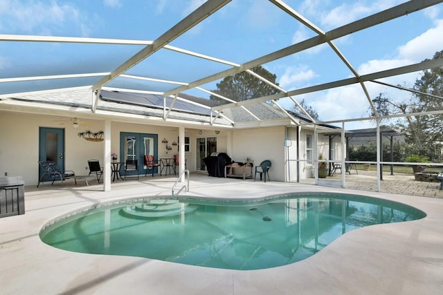 view of pool featuring french doors, ceiling fan, a lanai, and a patio area