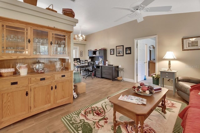 living room featuring lofted ceiling, ceiling fan with notable chandelier, and light wood-type flooring