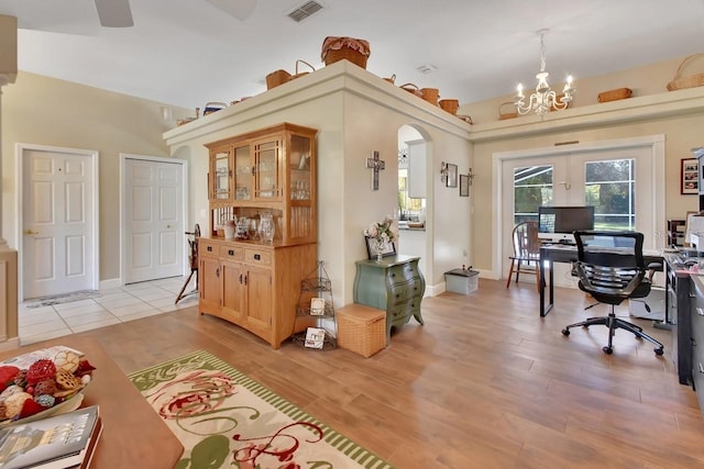 office space with a notable chandelier, light hardwood / wood-style floors, and french doors