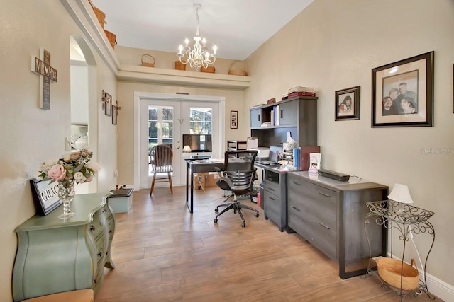 home office featuring a notable chandelier, light hardwood / wood-style floors, and french doors