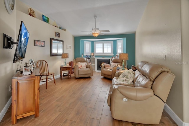 living room with lofted ceiling, light hardwood / wood-style flooring, and ceiling fan