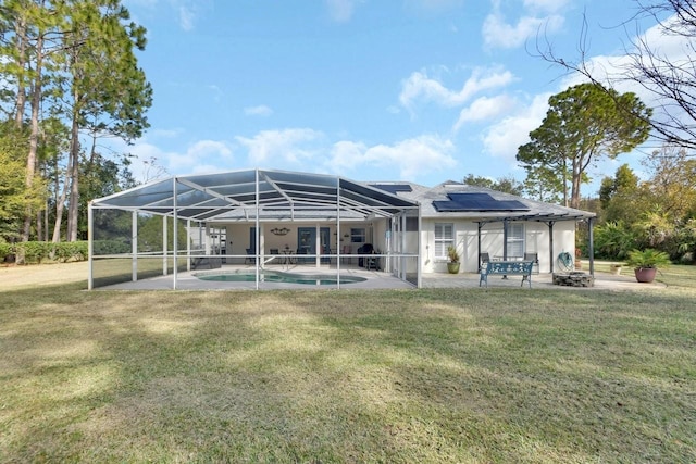 back of house featuring a yard, glass enclosure, and a patio area