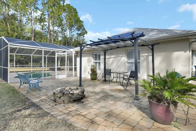 view of patio featuring an outdoor fire pit, a pergola, and glass enclosure