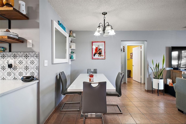 tiled dining space featuring a notable chandelier and a textured ceiling