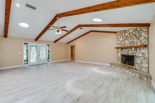 unfurnished living room with french doors, lofted ceiling with beams, light hardwood / wood-style flooring, ceiling fan, and a fireplace