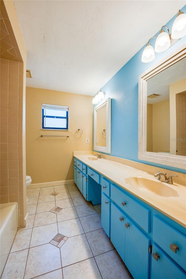 bathroom featuring vanity, tile patterned flooring, toilet, and a textured ceiling