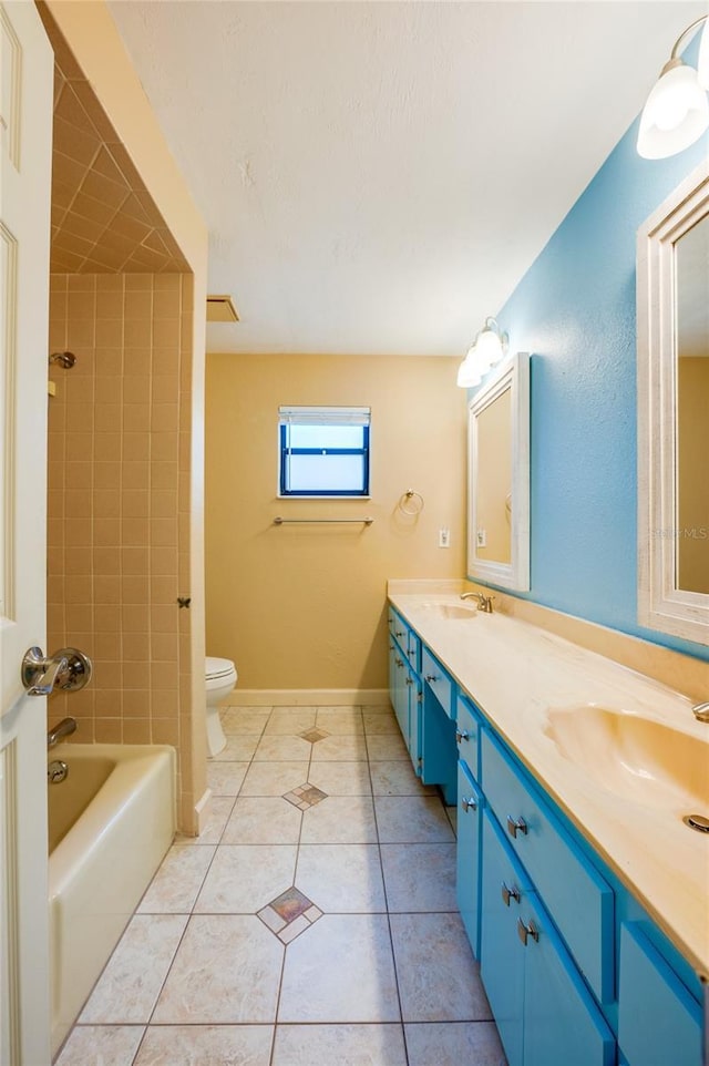 full bathroom featuring tile patterned flooring, vanity, tiled shower / bath combo, and toilet