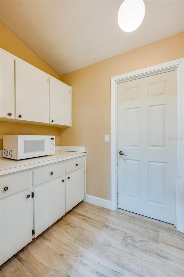 kitchen featuring white cabinetry and light hardwood / wood-style floors