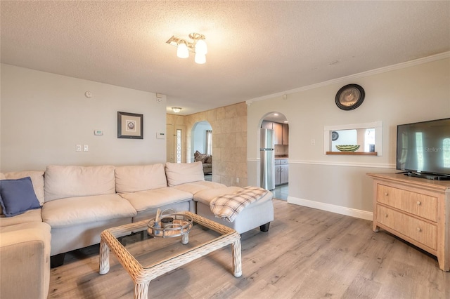 living room with ornamental molding, light hardwood / wood-style floors, and a textured ceiling