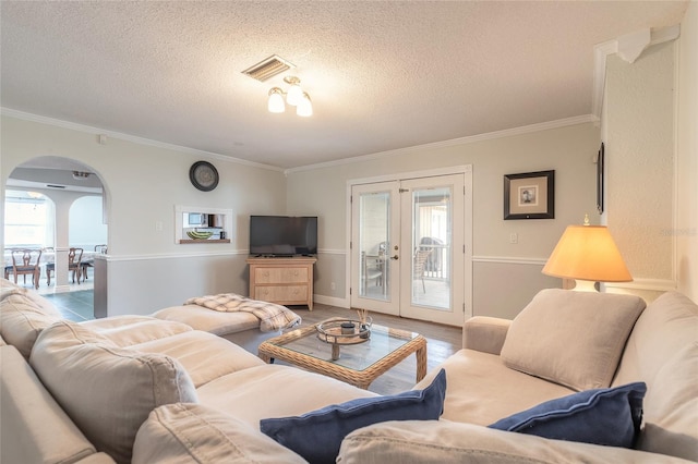 living room featuring crown molding, french doors, a textured ceiling, and hardwood / wood-style flooring