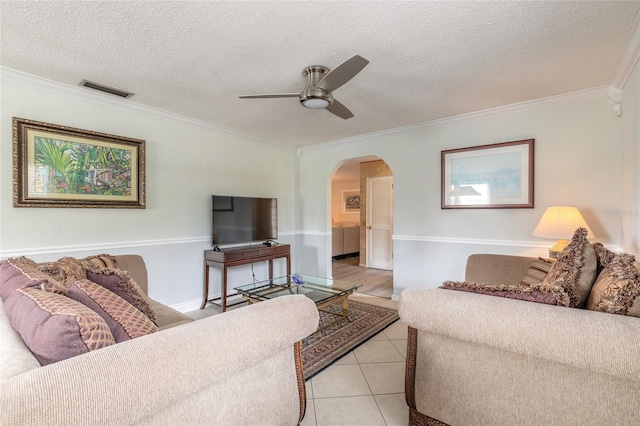 tiled living room featuring crown molding, a textured ceiling, and ceiling fan