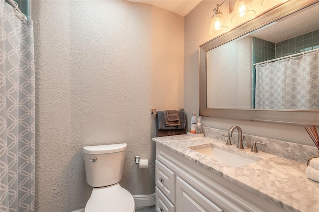 bathroom featuring walk in shower, vanity, and toilet