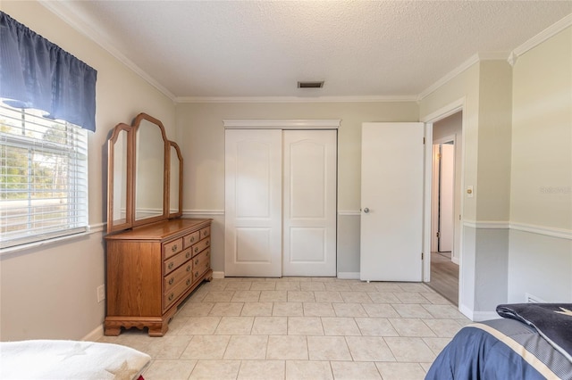 bedroom featuring crown molding, a textured ceiling, and a closet