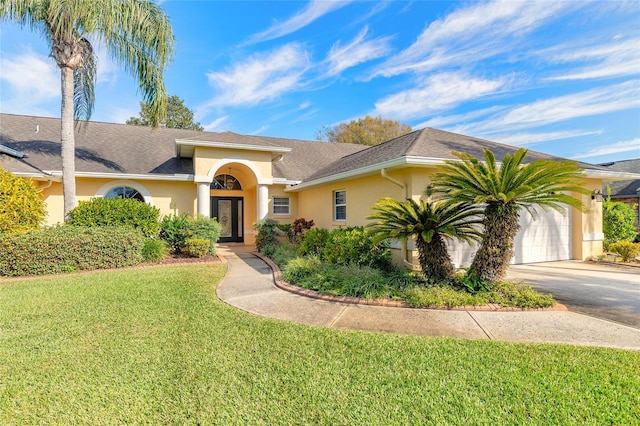 mediterranean / spanish home with a garage and a front lawn