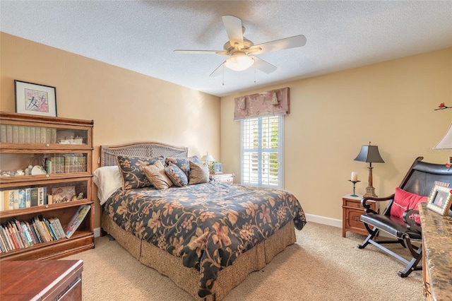 carpeted bedroom with ceiling fan and a textured ceiling