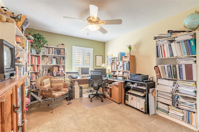 home office featuring ceiling fan, light carpet, and a textured ceiling