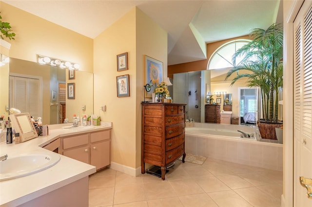 bathroom with vanity, a relaxing tiled tub, and tile patterned floors