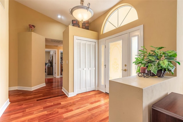 foyer entrance featuring hardwood / wood-style floors and vaulted ceiling