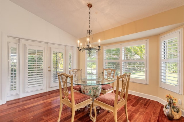 dining room with vaulted ceiling, a notable chandelier, dark hardwood / wood-style flooring, and french doors