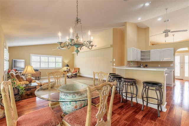 dining space featuring high vaulted ceiling, dark hardwood / wood-style flooring, and ceiling fan with notable chandelier