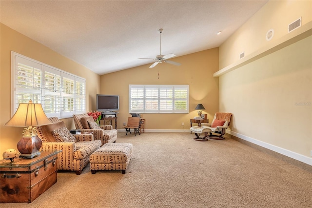 living area with vaulted ceiling, carpet flooring, a textured ceiling, and ceiling fan