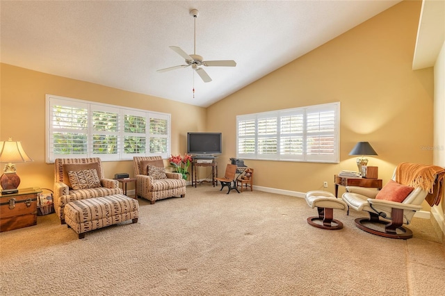 living area with ceiling fan, high vaulted ceiling, a healthy amount of sunlight, and carpet flooring