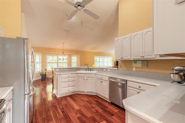 kitchen featuring sink, white cabinets, hanging light fixtures, kitchen peninsula, and stainless steel appliances