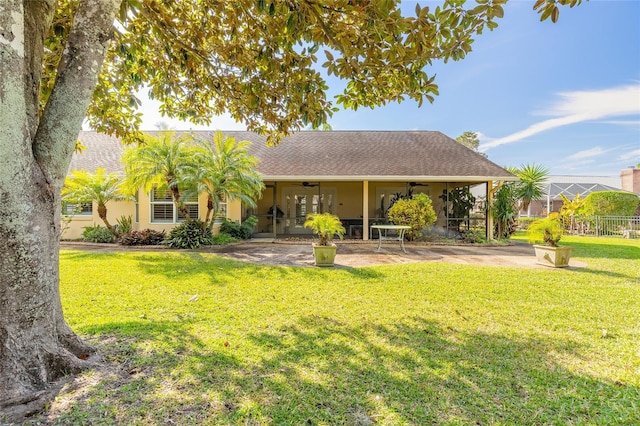 back of house with ceiling fan, a yard, and a patio