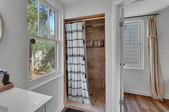 bathroom with a shower with curtain, vanity, hardwood / wood-style floors, and a wealth of natural light