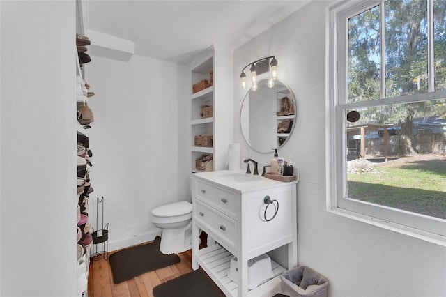 bathroom with hardwood / wood-style flooring, vanity, and toilet